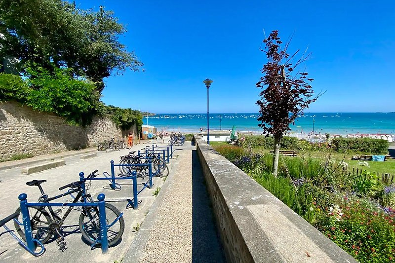 Location de vacances avec vélos, plage et vue sur l'océan.