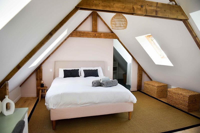 Chambre confortable avec mobilier en bois et linge de lit.