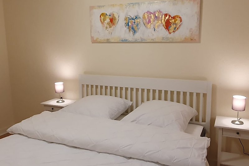 Gemütliches Schlafzimmer mit bequemem Bett, Holzmöbeln und stilvoller Beleuchtung.