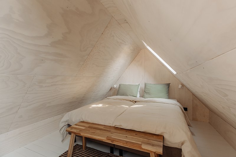 Een comfortabel houten bedframe met een plafond van gips.