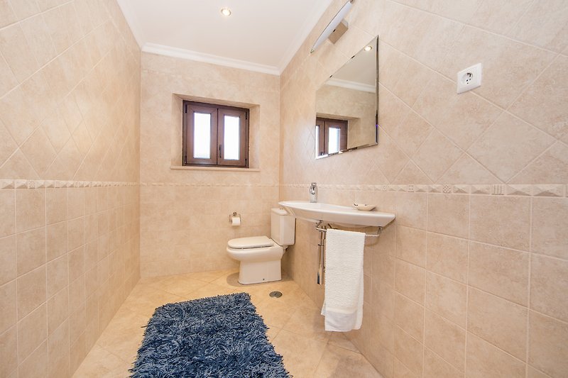 Gemütliches Badezimmer mit stilvoller Einrichtung und Spiegel.