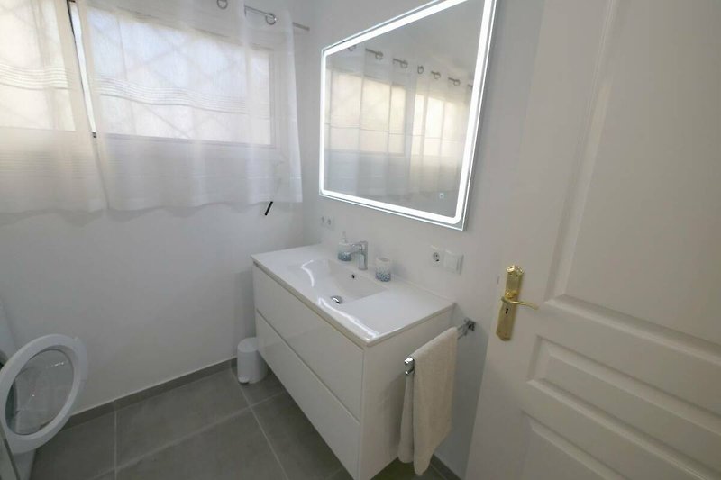Schönes Badezimmer mit stilvoller Inneneinrichtung und Spiegel.