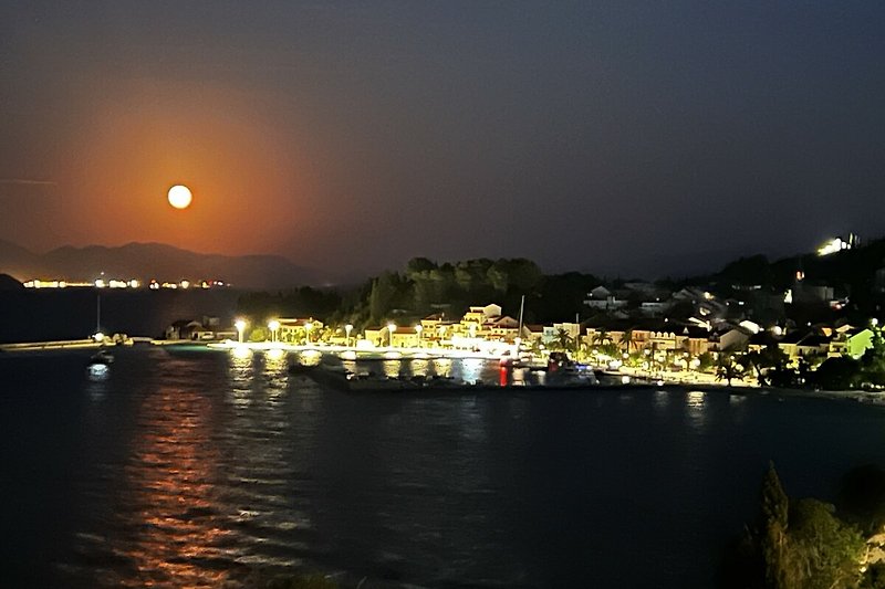 Experience the serene beauty of a moonlit lake at dusk, with a breathtaking horizon and a tranquil atmosphere.