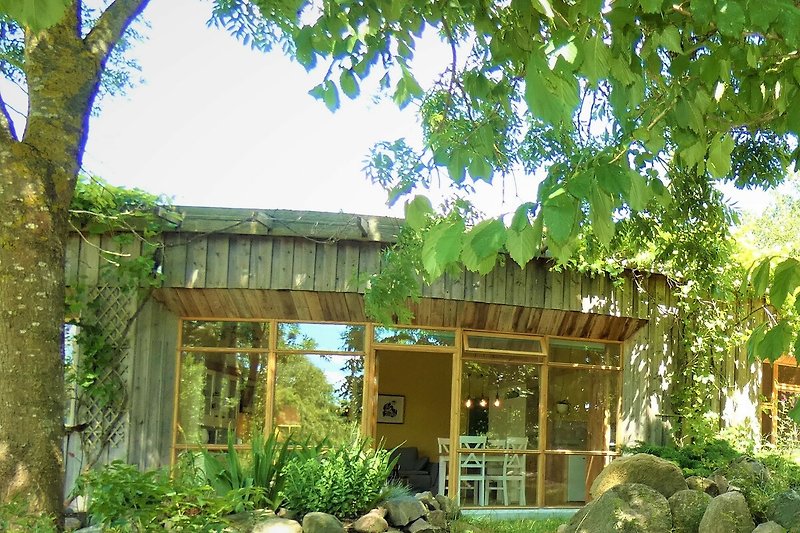 Verbringen Sie Ihren Urlaub in einem charmanten Holzhaus mit Blick auf eine grüne Landschaft.