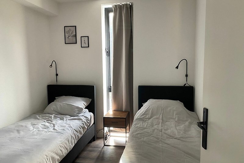 Schlafzimmer mit bequemem Bett, stilvollen Möbeln und Lampen.