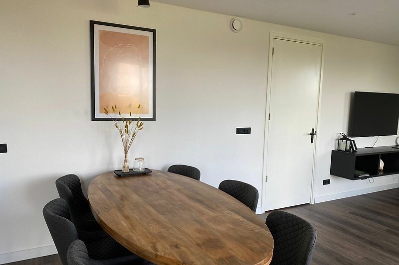 Gemütliches Wohnzimmer mit stilvollen Möbeln und Holzwand.