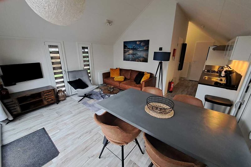 Gemütliches Wohnzimmer mit Holzmöbeln, Couch und Fernseher.