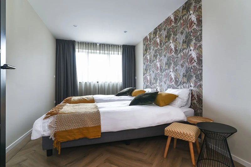 Gemütliches Schlafzimmer mit stilvoller Bettwäsche und Holzbett.