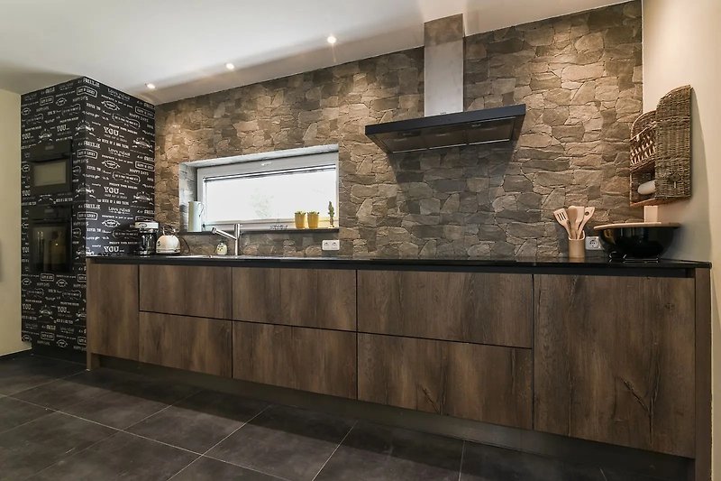 Schöne Küche mit grauen Schränken, Holztheke und stilvoller Inneneinrichtung.