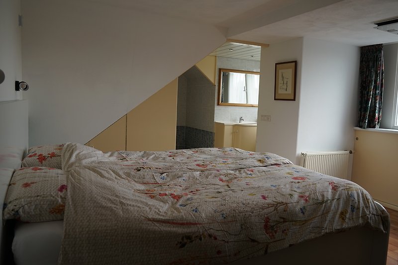 Een comfortabele slaapkamer met houten meubels en een prachtig uitzicht op het raam.