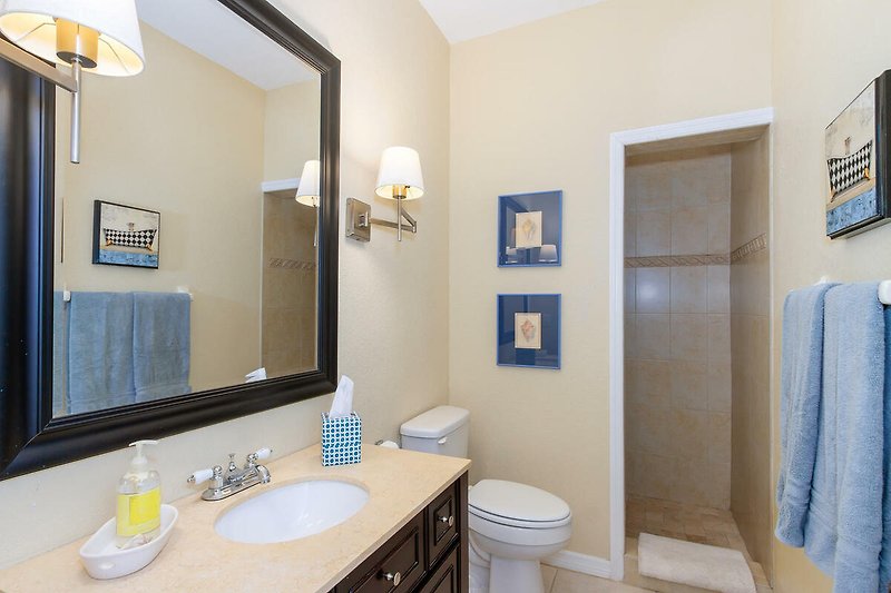 Schönes Badezimmer mit Spiegel, Waschbecken und lila Badezimmerschrank.