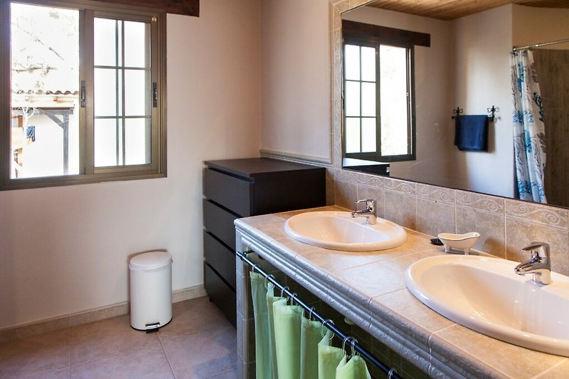 Una moderna stanza da bagno con un elegante lavandino e specchio.