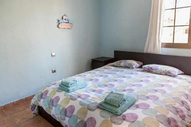 Una camera da letto con un comodo letto in legno e tessuti morbidi.
