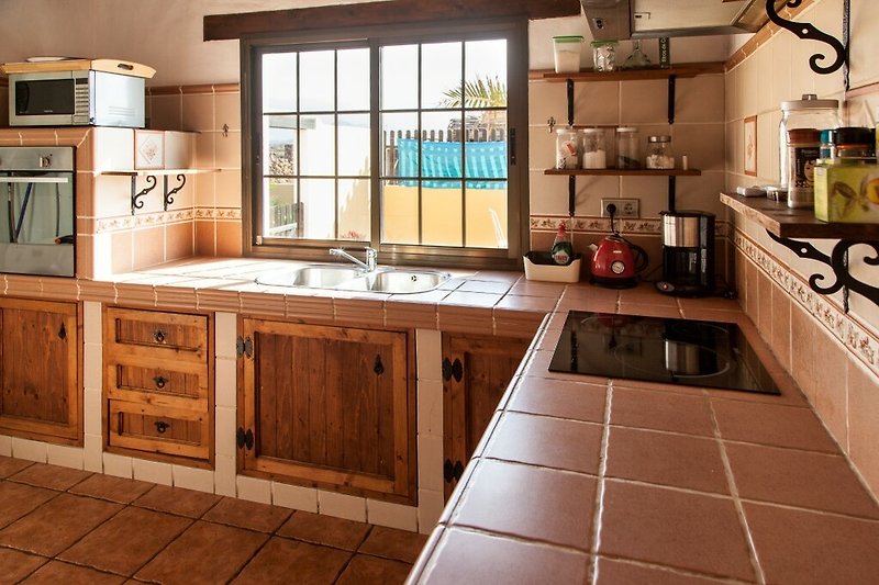 Una cucina moderna con un piano di lavoro in legno, mobili e un lavello.