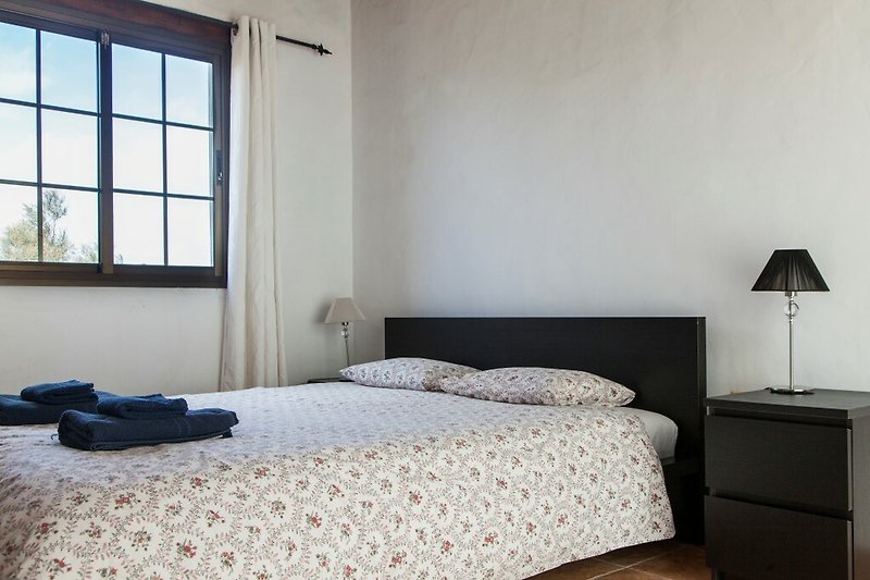 Una camera da letto accogliente con un letto in legno e un'illuminazione soffusa.