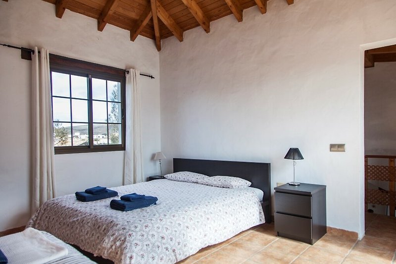 Una camera da letto con un comodo letto in legno e una finestra luminosa.