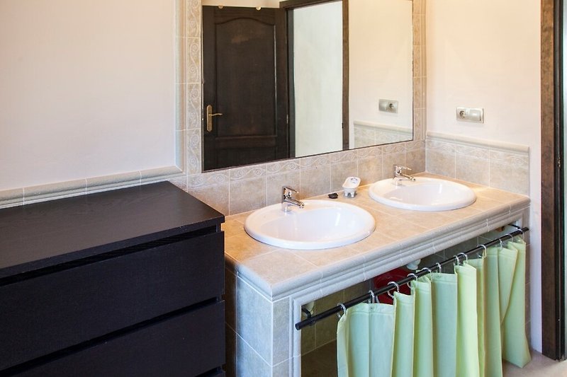 Un bagno elegante con lavandino in legno e specchio.