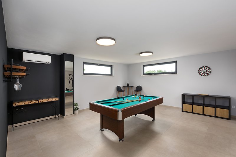 Elegant billiard room with stylish furniture and a pool table.