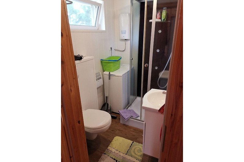Gemütliches Badezimmer mit lila Waschbecken und Toilette.