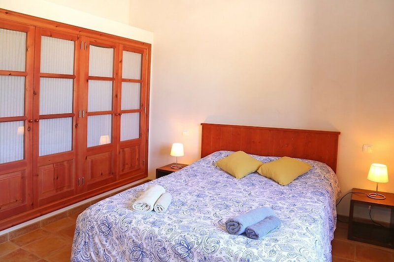 Hermoso dormitorio con muebles de madera y ropa de cama suave.