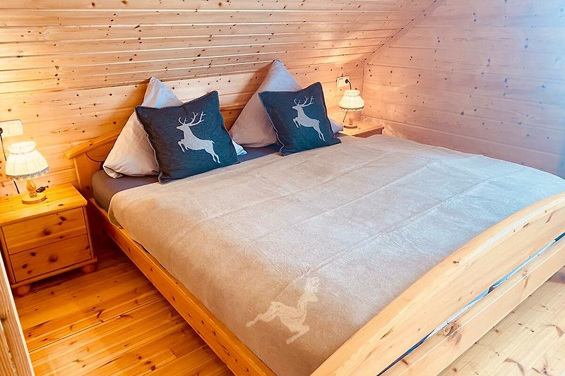 Gemütliches Doppelzimmer mit Holzmöbeln und komfortablem Bett.