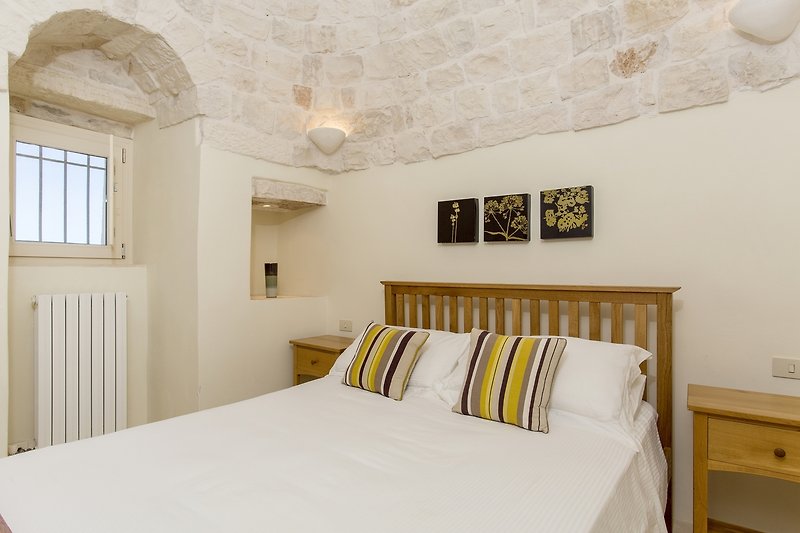Wake up to admire the huge 4 metre high stone trullo cone above the bed