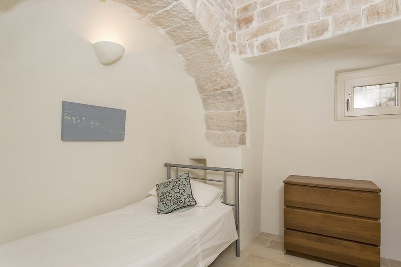 Bedroom with two single beds in the alcoves and a huge trullo dome above