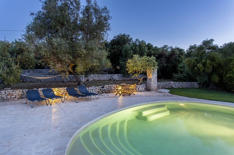 Escape to a lush garden oasis with a sparkling swimming pool and serene water feature.