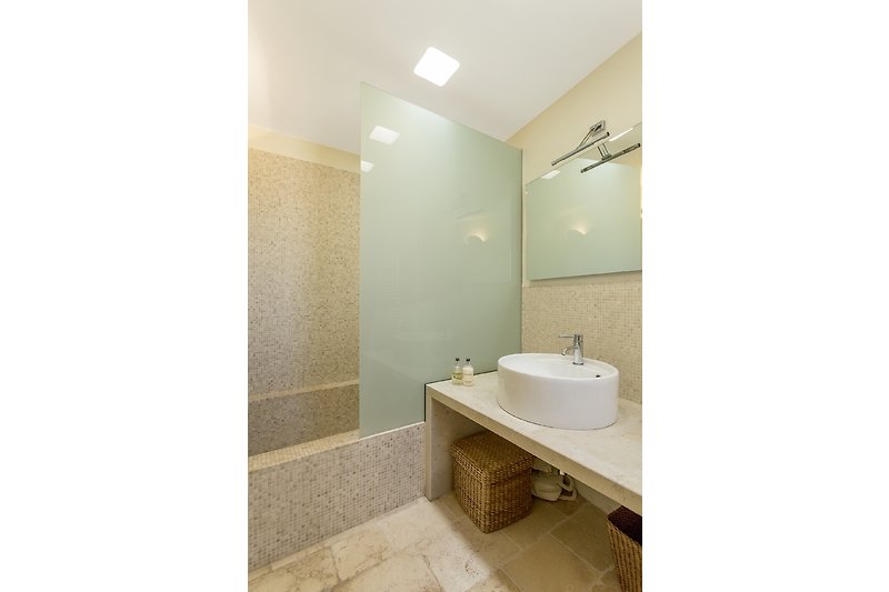 Rent this beautiful bathroom with a stylish sink, mirror, and elegant fixtures built in the original bread oven!