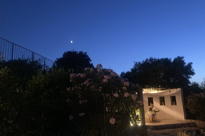 Experience a peaceful evening in this charming cottage with a full moon shining through the window.