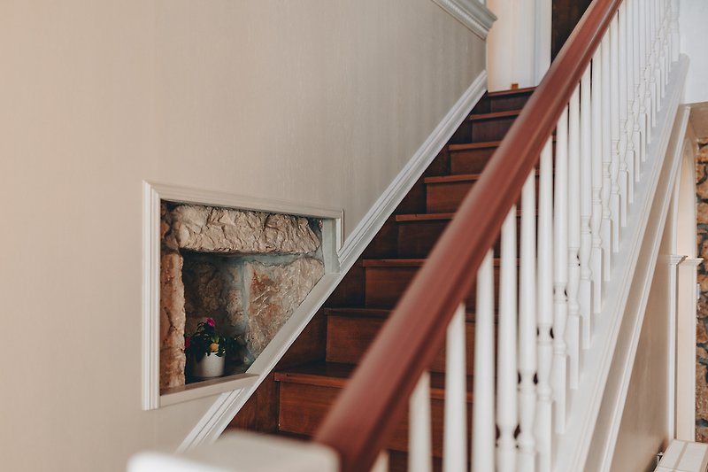 This picture showcases a beautiful interior design with wooden stairs and handrail.