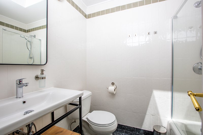 A modern bathroom with a sleek sink, mirror, and stylish fixtures.