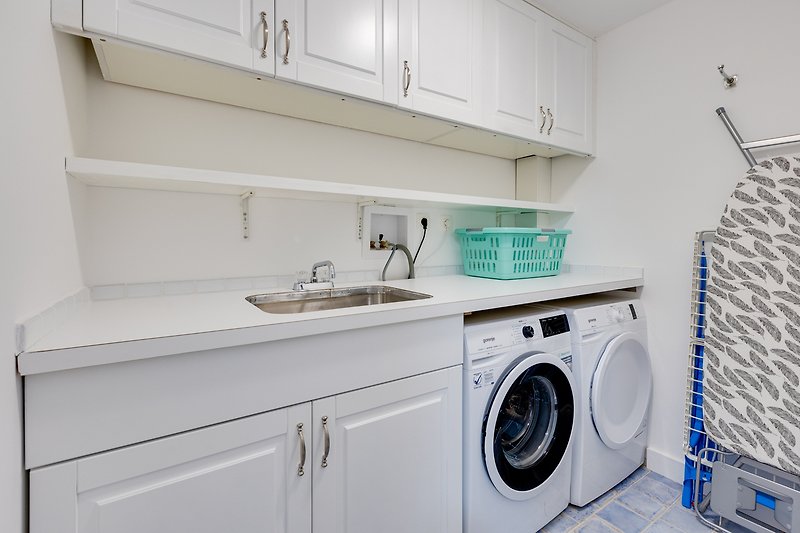 The villa has a laundry room equipped with a washing machine, dryer, iron, and sink.