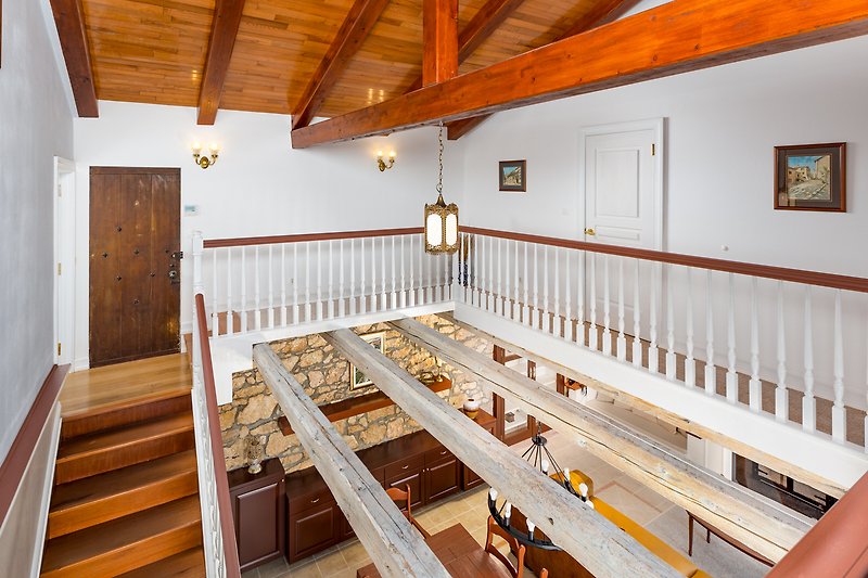 A beautifully designed house with elegant interior, hardwood beams, and large windows.