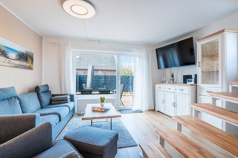 Gemütliches Wohnzimmer mit blauer Couch, Holzmöbeln und stilvollem Design.