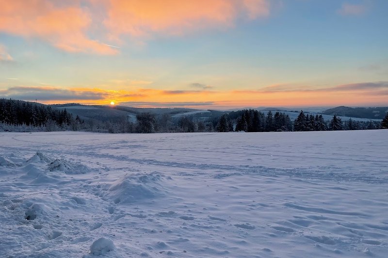 Prachtig winterlandschap met een betoverende zonsondergang boven het bevroren meer.