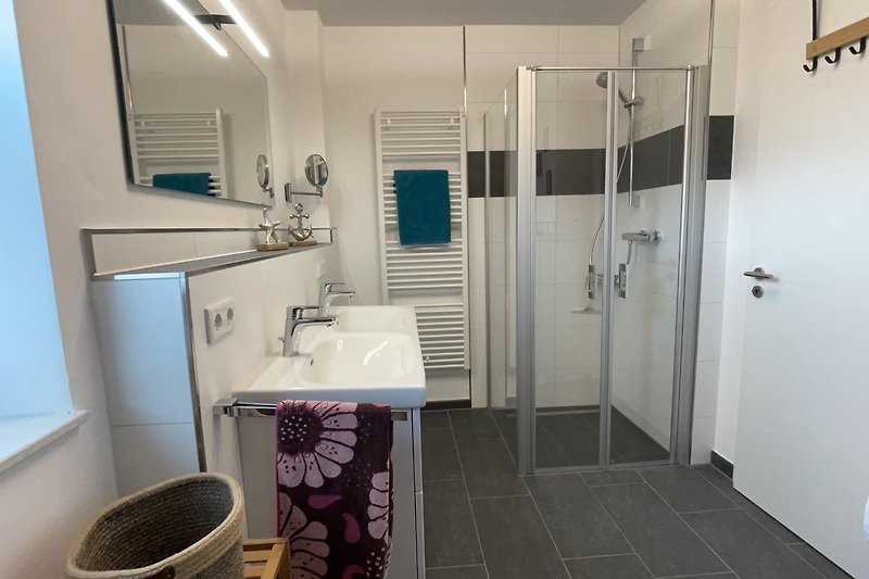 Moderne Badezimmerausstattung mit ebenerdiger Dusche und Doppelwaschtisch