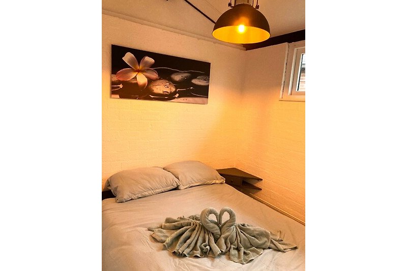 Een comfortabele slaapkamer met stijlvolle verlichting en houten meubels.