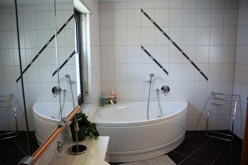 Schönes Badezimmer mit Whirlpool und edlen Fliesen.