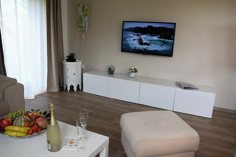 Gemütliches Wohnzimmer mit stilvollem Mobiliar und Flachbildfernseher.