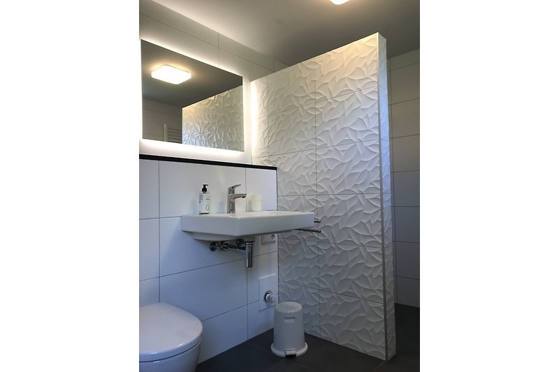 Ein stilvolles Badezimmer mit elegantem Spiegel und modernem Wasserhahn.
