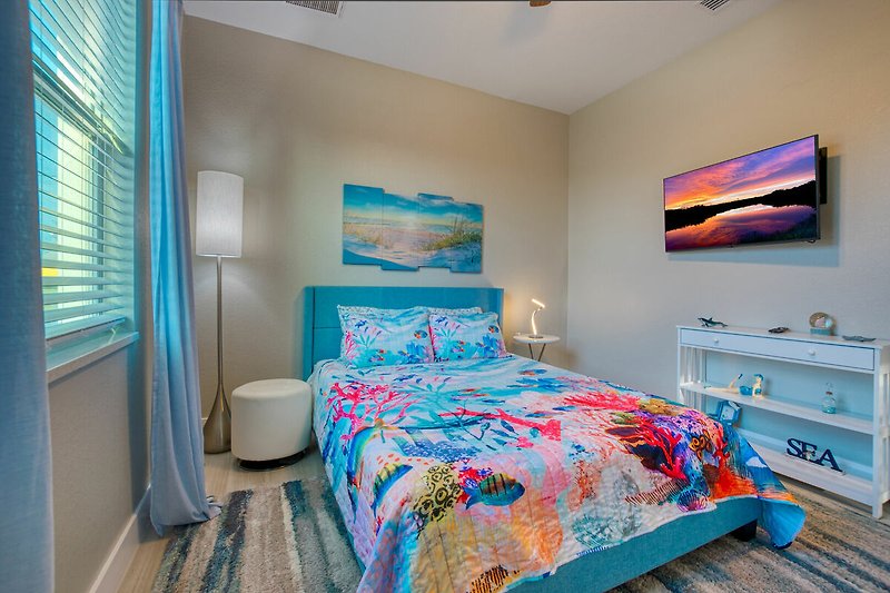 Gemütliches Schlafzimmer mit blauem Bett und stilvoller Einrichtung.