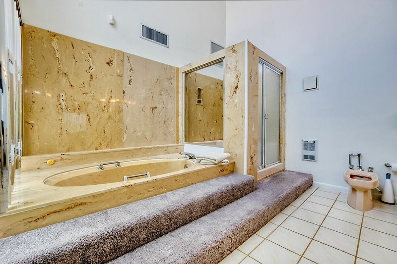 Schönes Badezimmer mit Holzboden, Spiegel und moderner Sanitärausstattung.