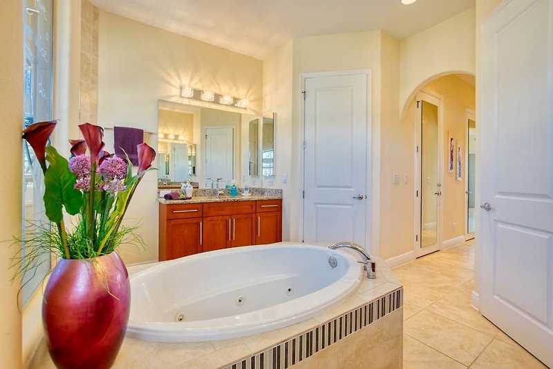 Schönes Badezimmer mit blühenden Pflanzen und stilvoller Beleuchtung.