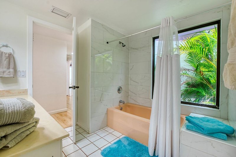 Modernes Badezimmer mit Glasdusche, Badewanne und Holzboden.