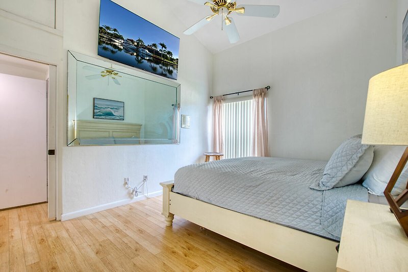 Gemütliches Schlafzimmer mit Holzmöbeln, blauem Bett und gemütlicher Beleuchtung.