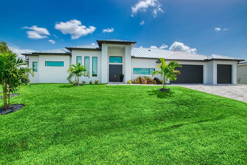 Schönes Haus mit grünem Garten und blauem Himmel.