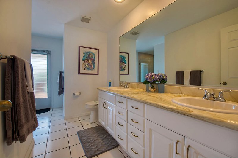 Modernes Badezimmer mit elegantem Waschtisch, Spiegel und stilvoller Beleuchtung.