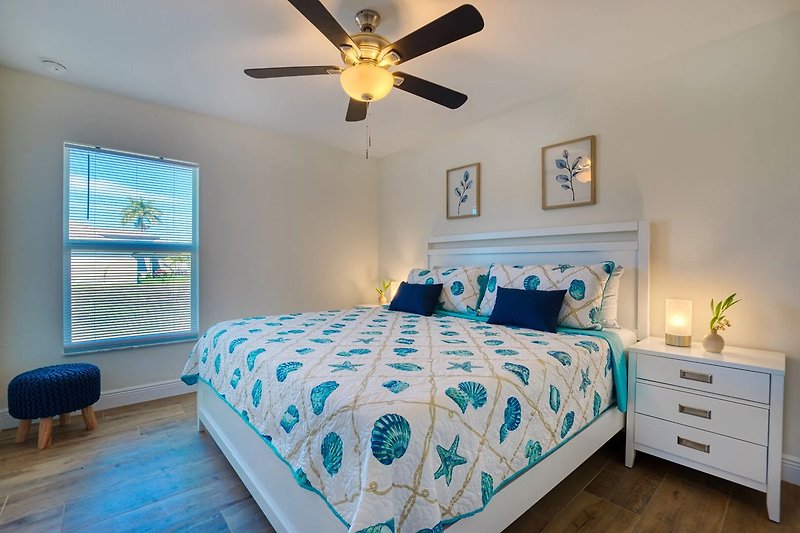 Gemütliches Schlafzimmer mit blauem Bett und stilvoller Dekoration.