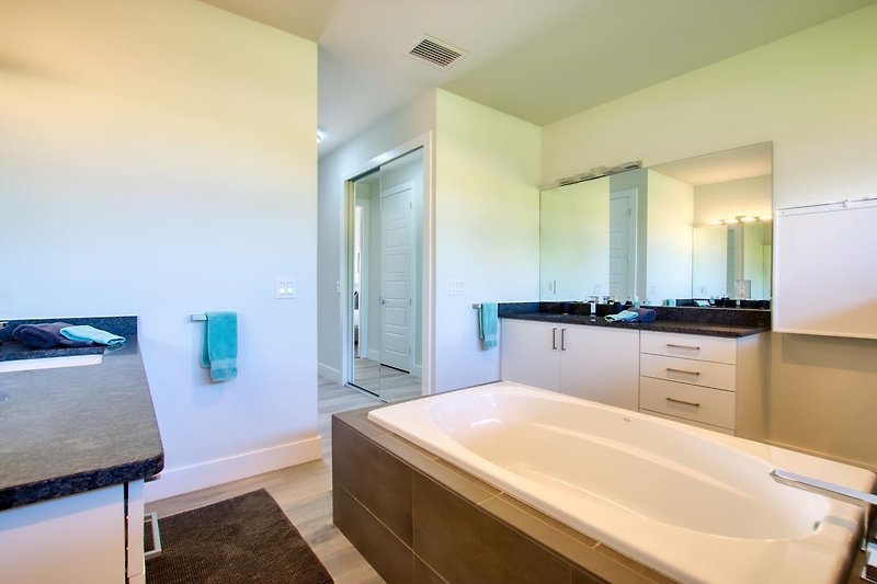 Ein stilvolles Badezimmer mit Holzmöbeln, Spiegel und Waschbecken.